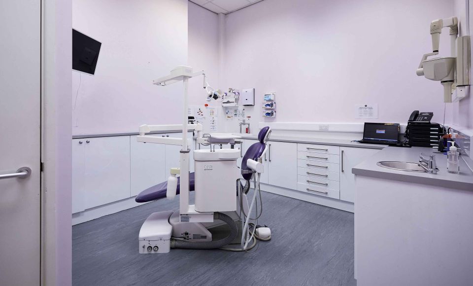 Zenith Cosmetic Dental treatment room with a dental chair, overhead light, cabinetry and X ray unit