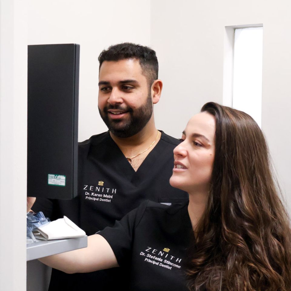Dr Karan Maini and Dr Stefania Stincone, Zenith principal dentists, examining dental equipment together in a clinic